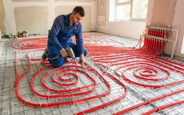 Pose d'un plancher chauffant basse température avec tubes PER en spirale dans une villa fribourgeoise